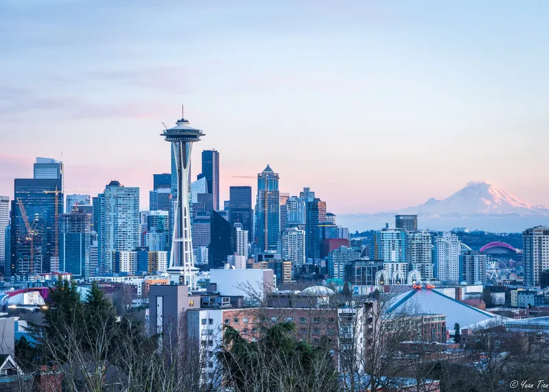 Seattle skyline at dusk from Kerry Park, with the Space Needle in front of a pink sky and Mount Rainier on the horizon